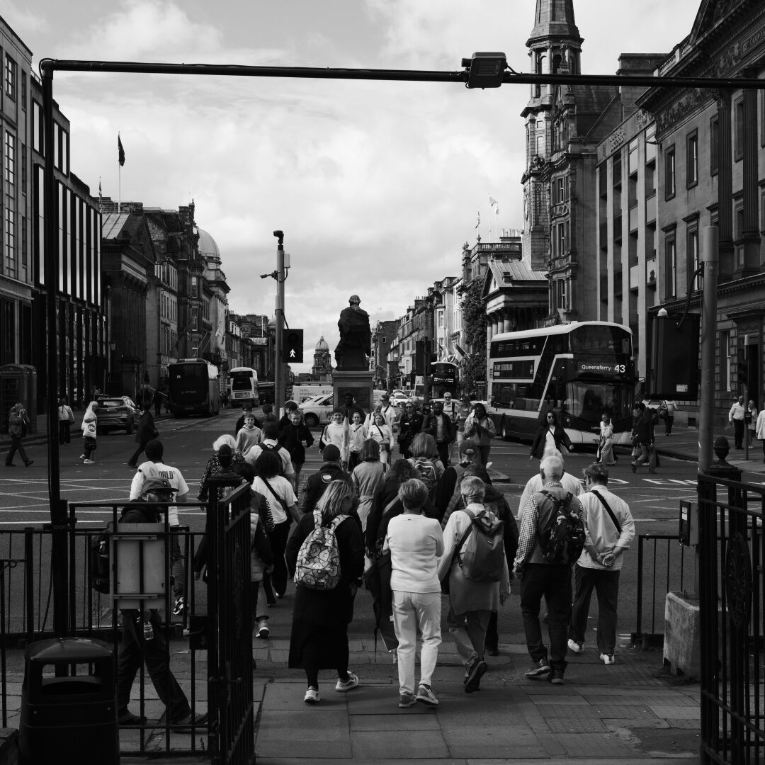 A crowd of tourists waits to cross into George Street.