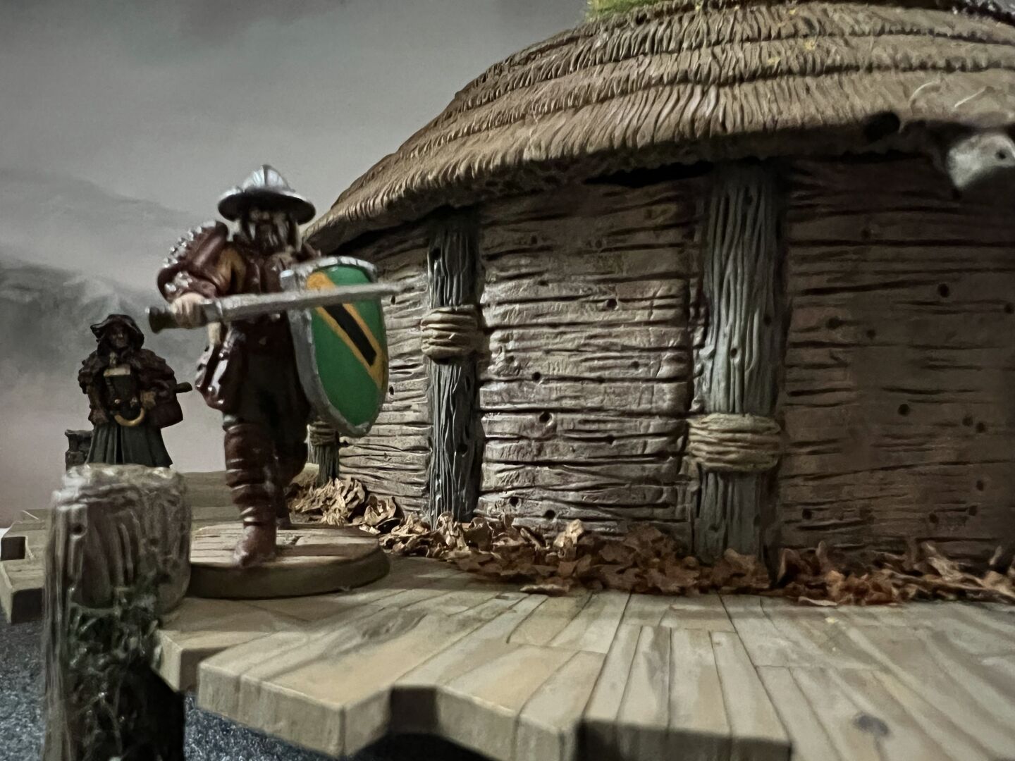 A close view of a crannog (ancient round house built on a wooden platform over a lake), perhaps seen from an approaching boat.