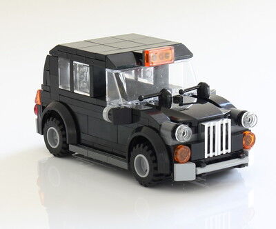 Lego build black cab seen from the front corner on a plain, white background